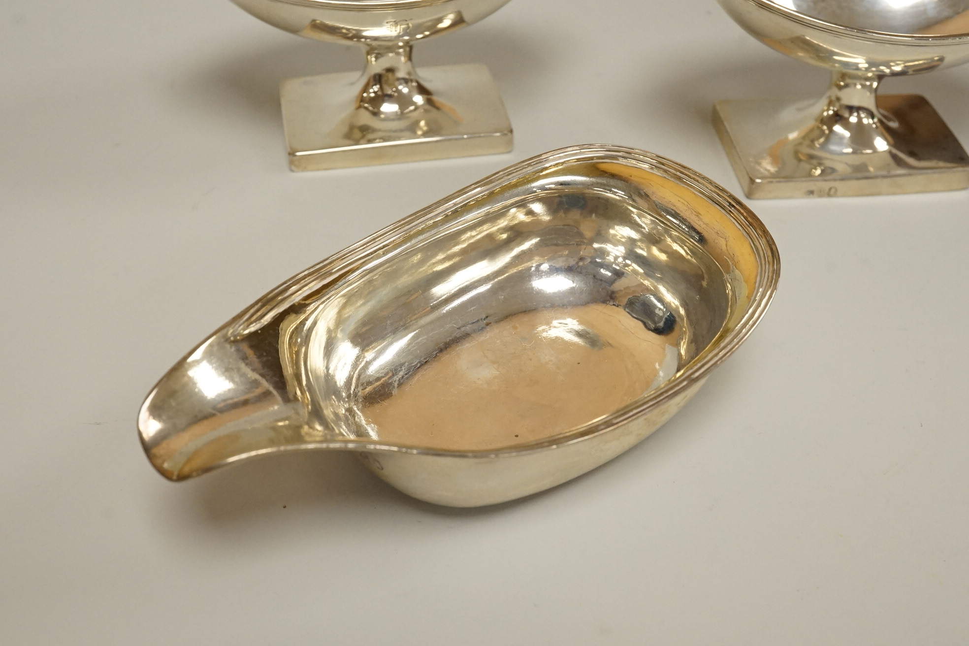 A George III silver pap boat, maker ?? and EB, London 1812, length 12.1 cm, together with a pair of Georgian Scottish silver boat shaped pedestal salts, maker RG, gross weight 7oz.